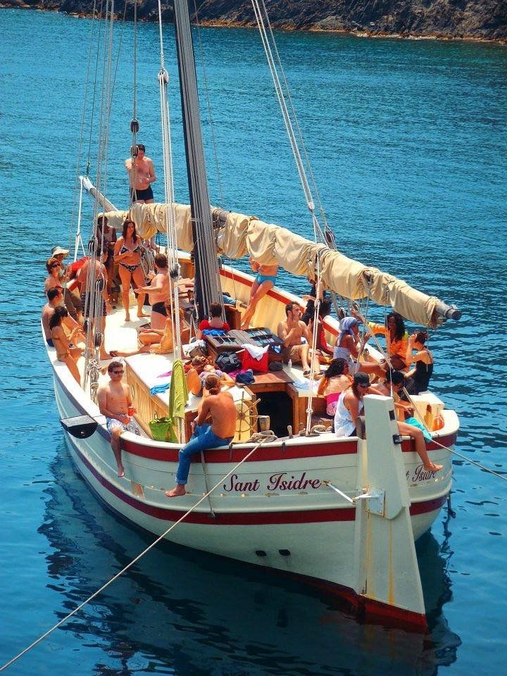 Barco tradicional Sant Isidre navegando frente a la costa de Cadaqués y el Cap de Creus